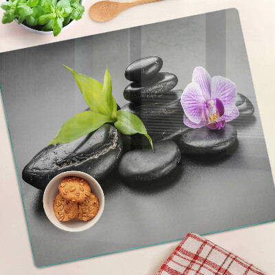 Sklenená doska na krájanie Kamene a orchidea na pozadí