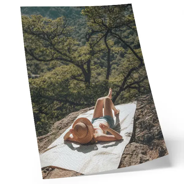 Plagát do obývačky relax na skale so zelenými stromami a klobúkom v prírode