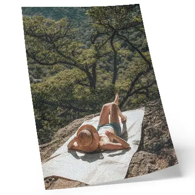 Plagát do obývačky relax na skale so zelenými stromami a klobúkom v prírode