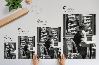 Poster na stenu Žena s klobúkom pri stole v kaviarni